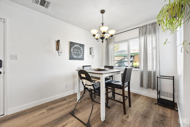 dining room with ornamental molding, dark hardwood / wood-style flooring, and a chandelier