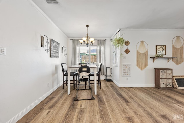 dining room featuring ornamental molding, hardwood / wood-style floors, and an inviting chandelier