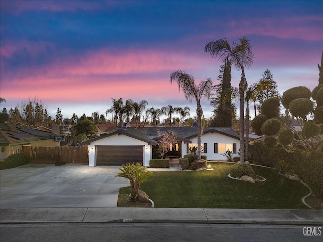 single story home featuring a garage and a yard