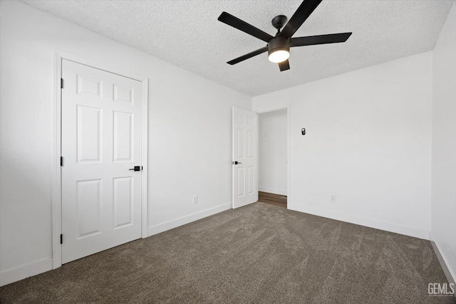 unfurnished bedroom featuring ceiling fan, a textured ceiling, and dark colored carpet