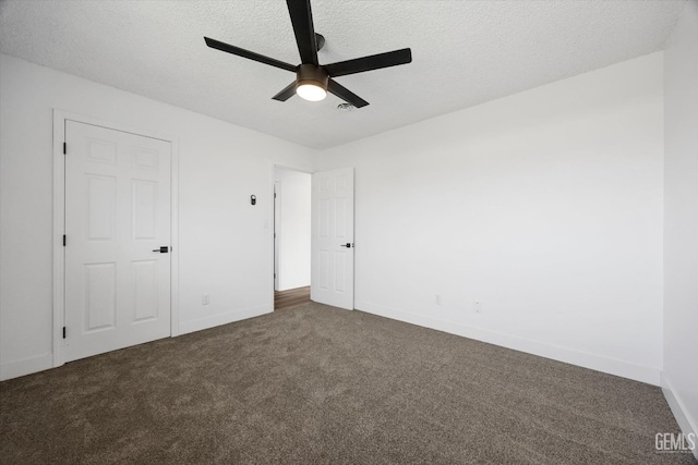 unfurnished bedroom with dark colored carpet, ceiling fan, and a textured ceiling