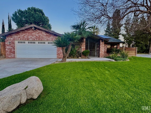 ranch-style home featuring a garage, concrete driveway, brick siding, and a front yard