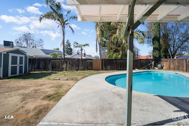 view of pool featuring a fenced backyard, a storage shed, an outdoor structure, a fenced in pool, and a patio area