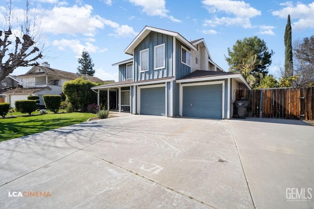 view of front of property featuring concrete driveway, an attached garage, board and batten siding, a front yard, and fence