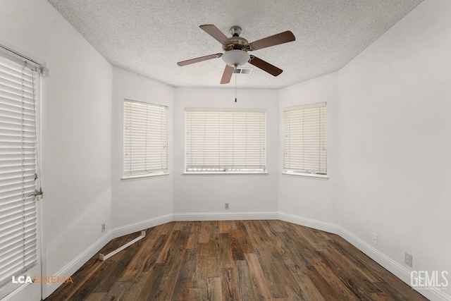 unfurnished room with dark wood-style floors, a textured ceiling, baseboards, and a ceiling fan