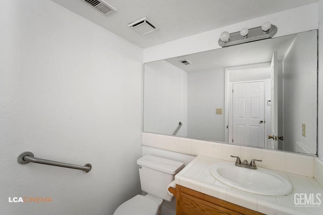 bathroom featuring visible vents, vanity, and toilet