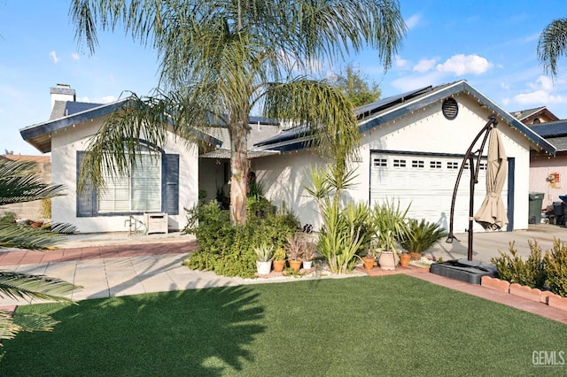 view of front of property with solar panels, a front lawn, and a garage