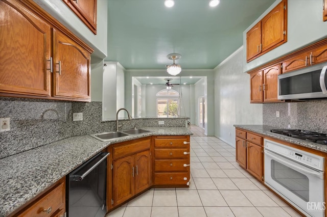 200 Justin Ct, Shafter, CA 93263 - kitchen featuring appliances with stainless steel finishes, brown cabinets, light tile patterned flooring, ornamental molding, and recessed lighting