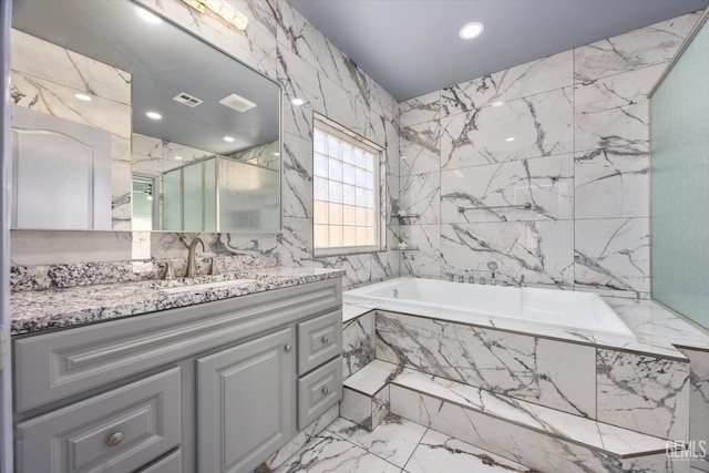 200 Justin Ct, Shafter, CA 93263 - bathroom featuring marble tiled flooring, tile walls, vanity, a garden tub, and a marble finish shower