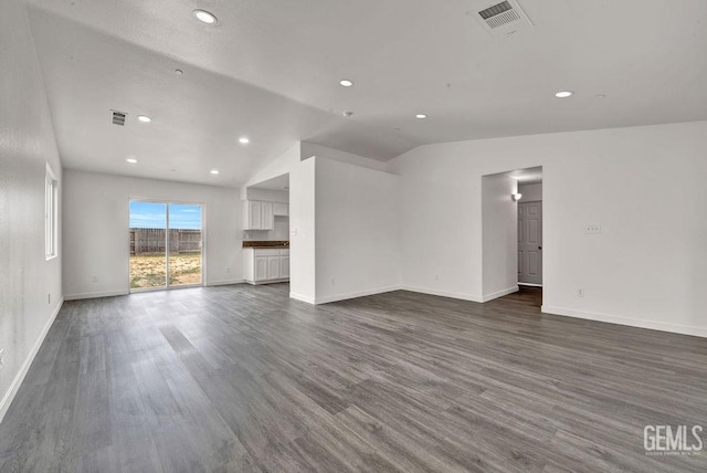 313 Mission St, Mc Farland, CA 93250 - unfurnished living room featuring visible vents, baseboards, dark wood-style flooring, and lofted ceiling