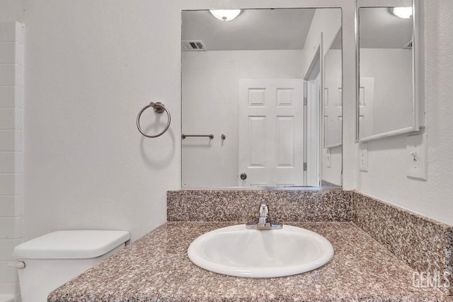 313 Mission St, Mc Farland, CA 93250 - bathroom featuring visible vents, toilet, and vanity