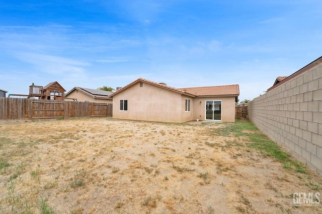 313 Mission St, Mc Farland, CA 93250 - back of house featuring a fenced backyard, stucco siding, and a tiled roof