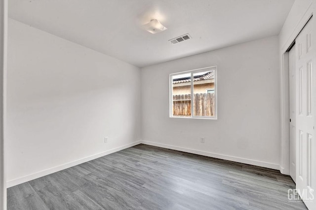 313 Mission St, Mc Farland, CA 93250 - unfurnished bedroom with baseboards, a closet, wood finished floors, and visible vents