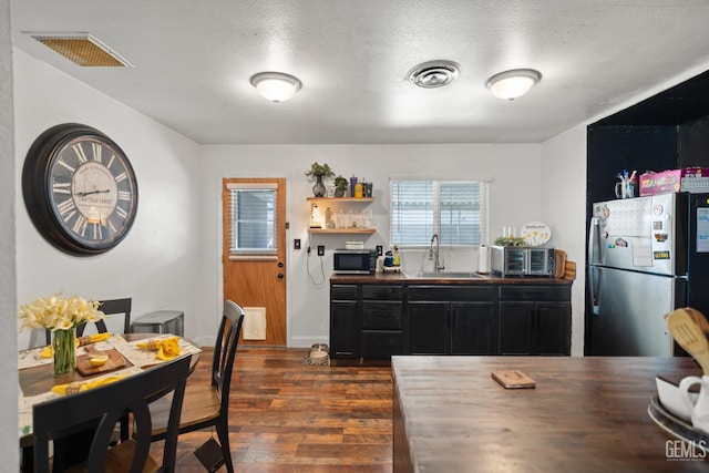 262 Olson Ave, Shafter, CA 93263 - kitchen featuring appliances with stainless steel finishes, dark wood finished floors, dark cabinets, butcher block countertops, and a textured ceiling