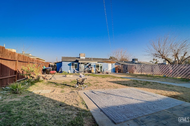 back of house with a patio and a lawn