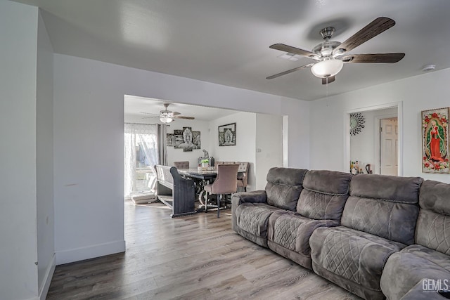 living room with wood-type flooring and ceiling fan