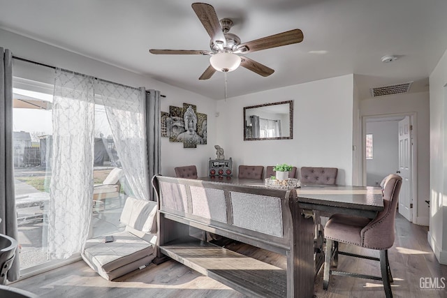 dining space with hardwood / wood-style flooring and ceiling fan