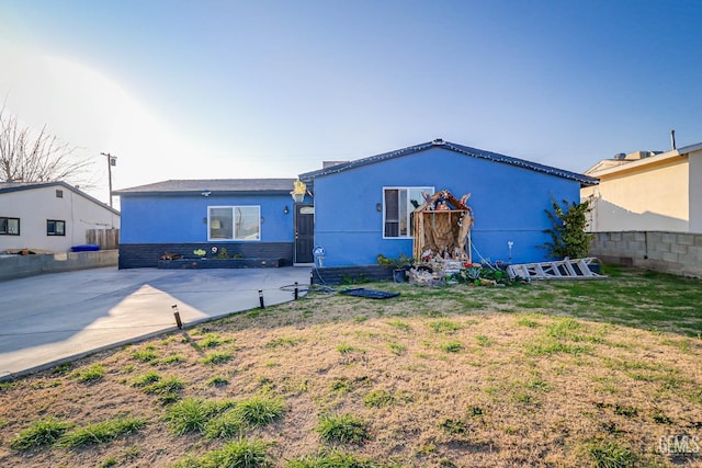 view of front of property featuring a front lawn and a patio area