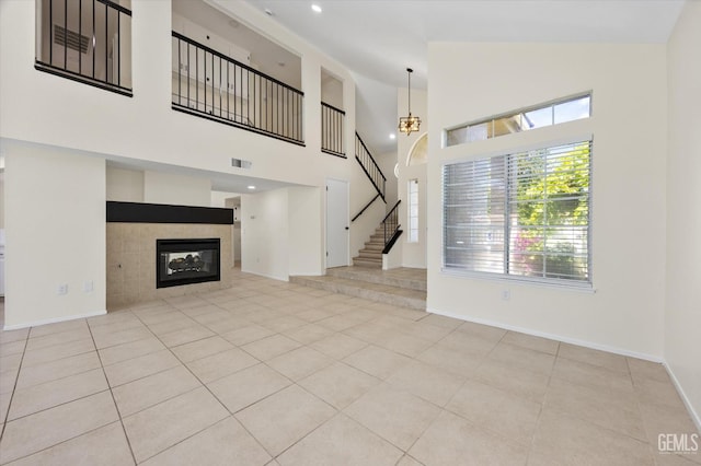 6209 Ambergrove St, Bakersfield, CA 93313 - unfurnished living room with stairway, tile patterned flooring, high vaulted ceiling, and a tile fireplace