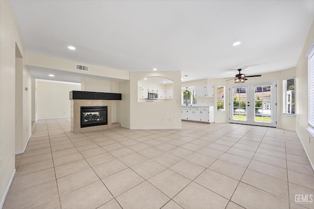 6209 Ambergrove St, Bakersfield, CA 93313 - unfurnished living room with ceiling fan, light tile patterned floors, french doors, a tiled fireplace, and recessed lighting