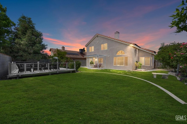 6209 Ambergrove St, Bakersfield, CA 93313 - back of house at dusk with a chimney, a deck, and stucco siding