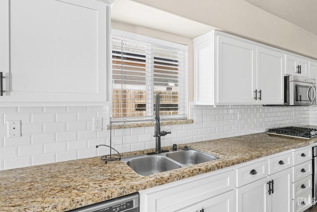 15020 Cotton Blossom Ave, Bakersfield, CA 93314 - kitchen featuring stainless steel appliances, white cabinetry, a sink, tasteful backsplash, and light stone countertops