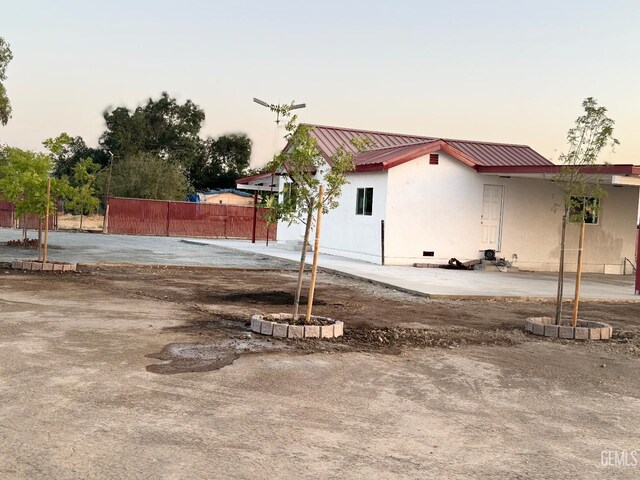 28112 Pond Rd, Wasco, CA 93280 - property exterior at dusk with a metal roof and crawl space