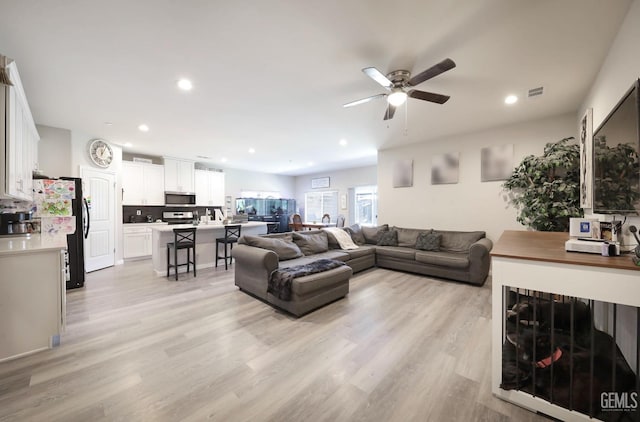 living area with recessed lighting, light wood-type flooring, visible vents, and a ceiling fan