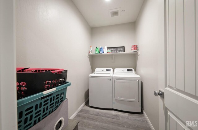 8317 Littleton St, Bakersfield, CA 93314 - washroom featuring wood finished floors, baseboards, washer and clothes dryer, and laundry area