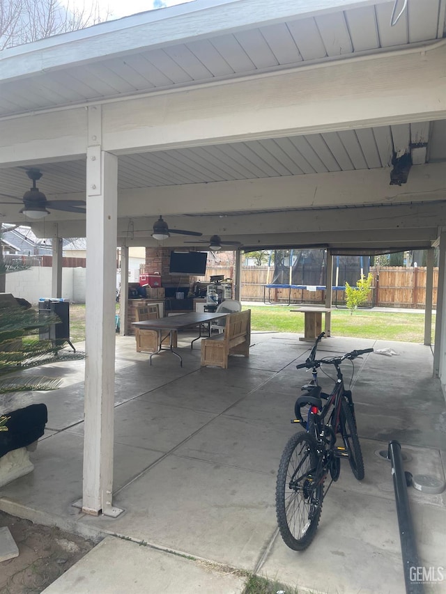 garage featuring a trampoline, a yard, and ceiling fan