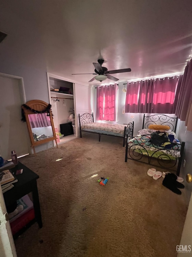 carpeted bedroom with ceiling fan and a closet