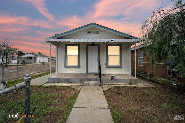 bungalow with covered porch and fence