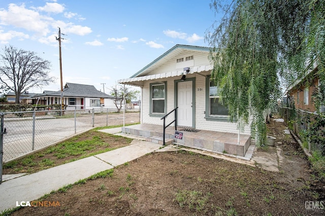 bungalow-style home featuring covered porch and fence