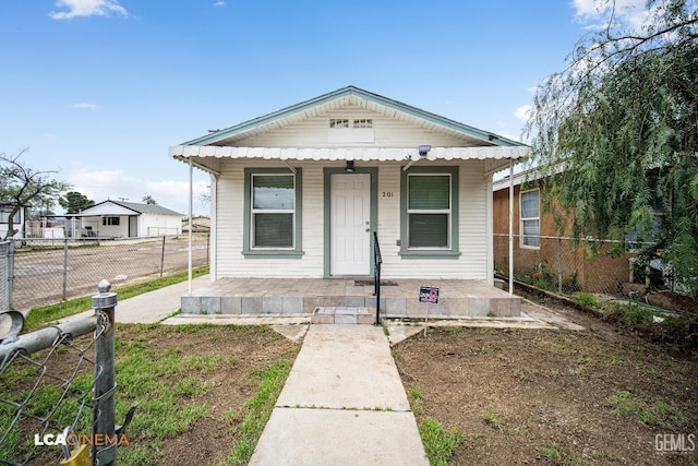 view of front of home with a porch and fence