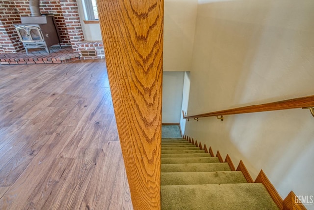 stairs featuring hardwood / wood-style flooring and a wood stove