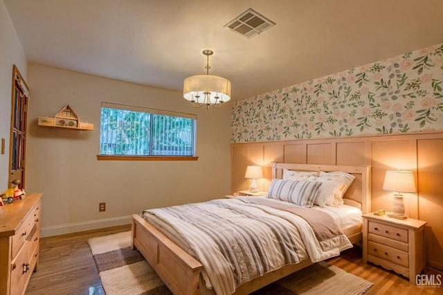 bedroom featuring hardwood / wood-style flooring and a notable chandelier