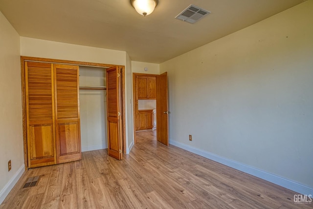 unfurnished bedroom featuring light hardwood / wood-style floors and a closet