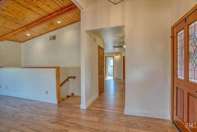 foyer entrance featuring vaulted ceiling with beams, wooden ceiling, and light hardwood / wood-style floors