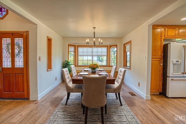 dining room featuring light hardwood / wood-style floors and a notable chandelier