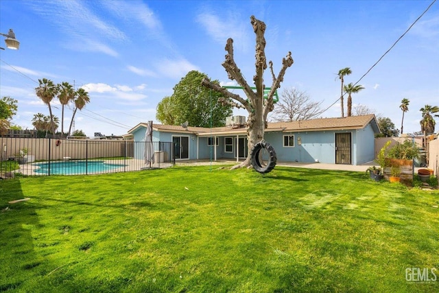 back of property featuring a fenced in pool, fence, a patio, and a yard