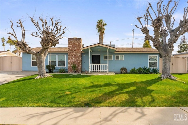 ranch-style house with a front yard, a chimney, an outbuilding, and stucco siding