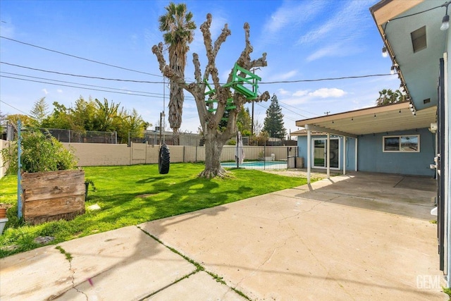 view of yard with a patio, a carport, a fenced backyard, and a fenced in pool