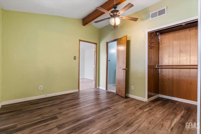 unfurnished bedroom featuring baseboards, visible vents, dark wood-type flooring, vaulted ceiling with beams, and a closet