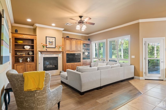 2801 Trengate Way, Bakersfield, CA 93311 - living room featuring a ceiling fan, crown molding, a glass covered fireplace, light wood-style flooring, and recessed lighting