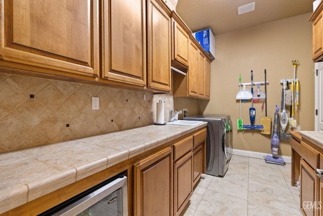 2801 Trengate Way, Bakersfield, CA 93311 - washroom featuring washing machine and clothes dryer, cabinet space, beverage cooler, and light tile patterned flooring