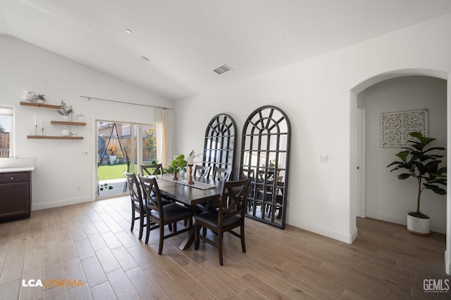 3312 Whispering Brook Ln, Shafter, CA 93263 - dining area with arched walkways, light wood-style floors, and vaulted ceiling