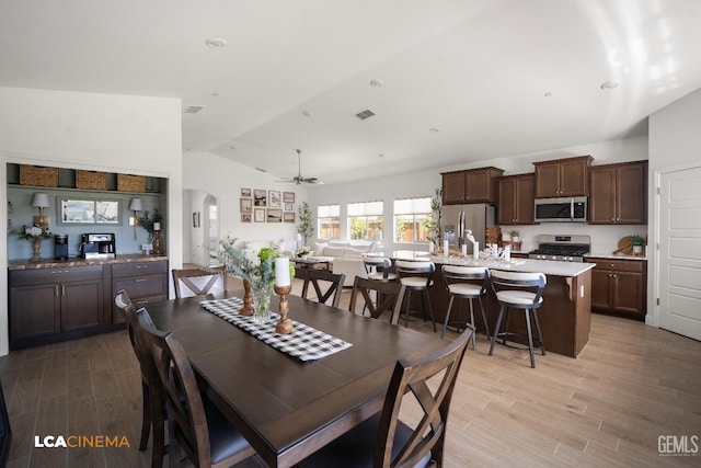 3312 Whispering Brook Ln, Shafter, CA 93263 - dining area featuring lofted ceiling, arched walkways, light wood finished floors, and ceiling fan