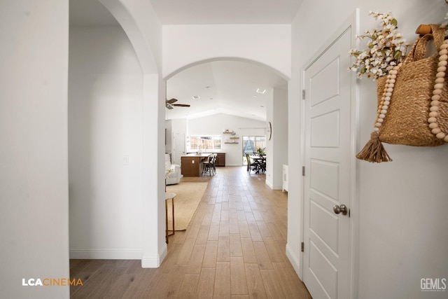 3312 Whispering Brook Ln, Shafter, CA 93263 - corridor featuring arched walkways, vaulted ceiling, and light wood-type flooring