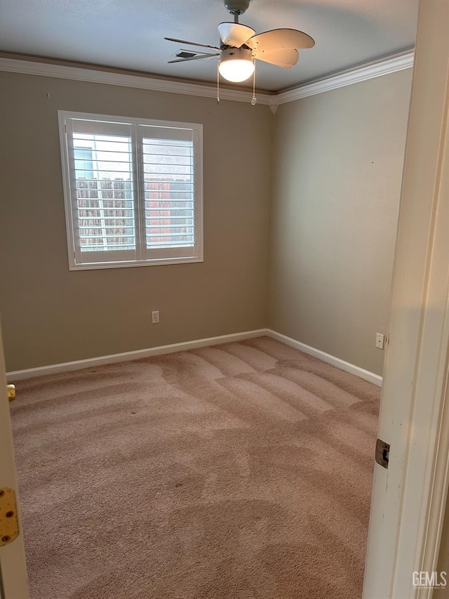 carpeted spare room featuring crown molding and ceiling fan