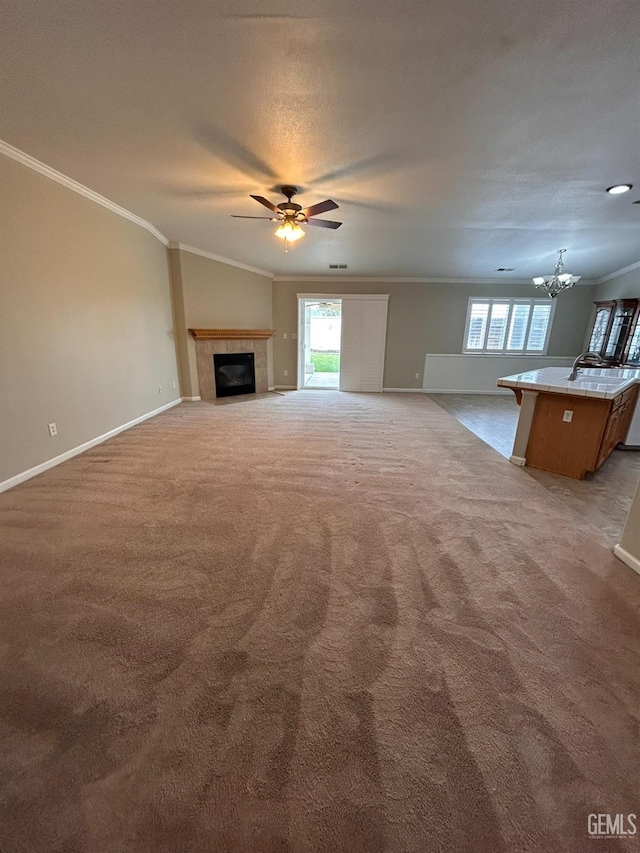 unfurnished living room with a tile fireplace, ornamental molding, and a wealth of natural light